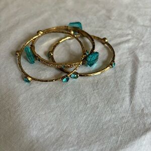 Set of 3 Faux Aquamarine Gold-tone bangle bracelets.